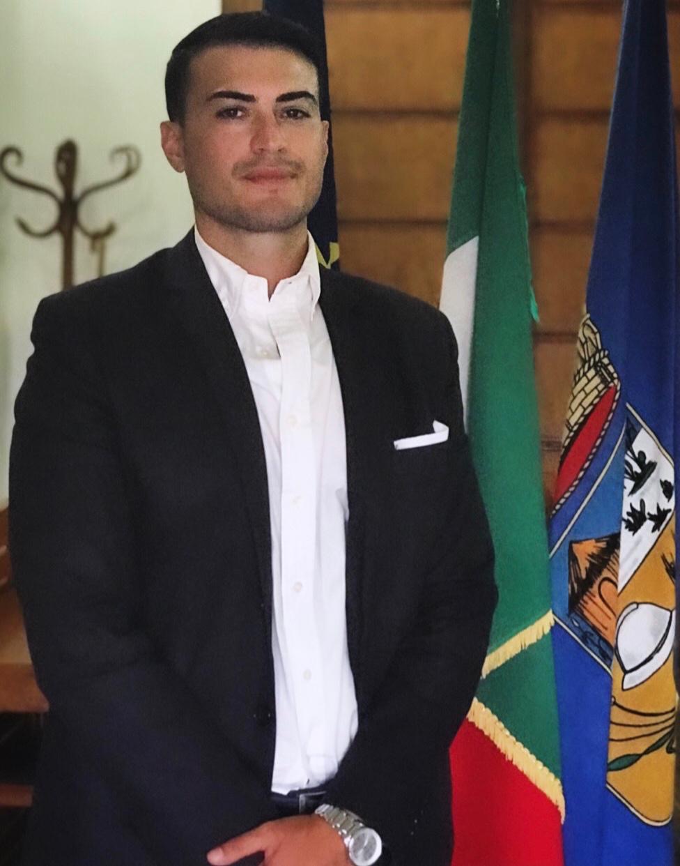 Tiziano Lauri davanti alle bandiere italiana e del Comune di Sabaudia